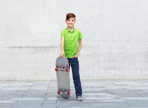 happy boy with skateboard over street background - Fotografie, Obrázek