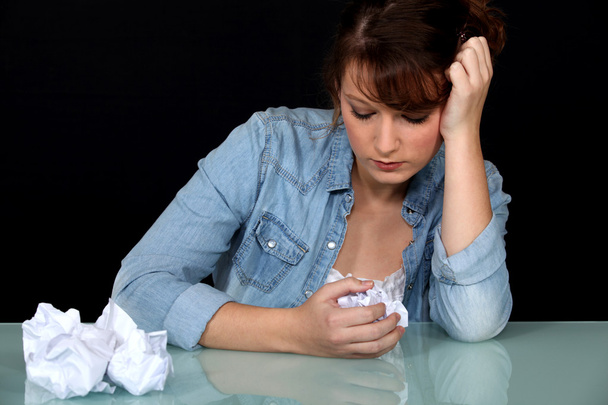 Depressed woman crumpling up paper into balls - Zdjęcie, obraz