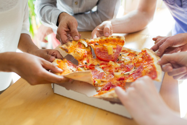 close up of friends or people eating pizza - Fotografie, Obrázek