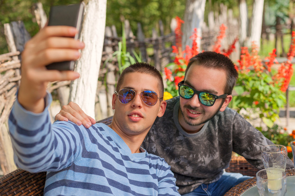 Two young boys smiling and taking selfie outdoors - Photo, Image