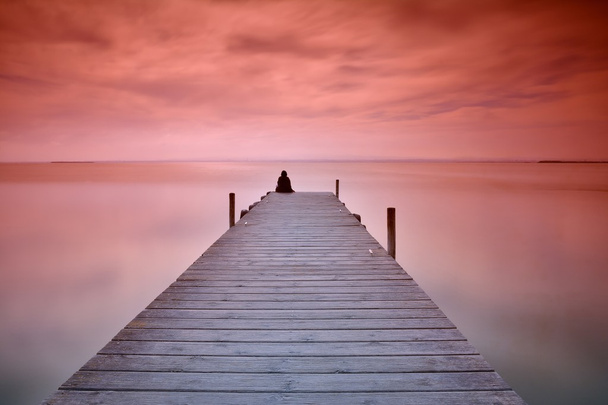 Lonely person sitting on pier - Photo, Image