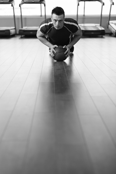 Exercice de jeune homme avec la boule médicale dans le club de forme physique
 - Photo, image