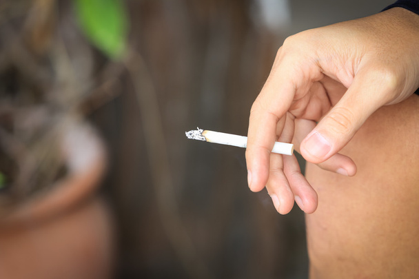 Крупним планом рука тримає цигарку. зупинити паління, вибірковий фокус
 - Фото, зображення