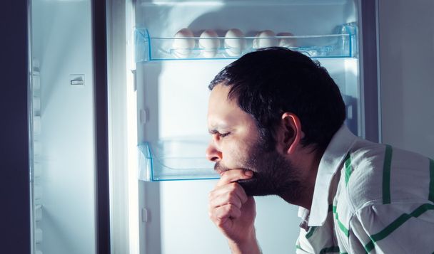 Lustiger Mann schaut in Kühlschrank - Foto, Bild