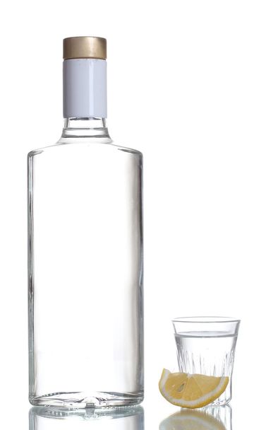Bottle of vodka and wineglass with lemon isolated on white - Foto, Imagem