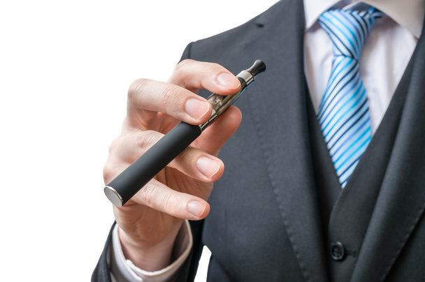 Бизнесмен держит в руках электронную сигарету. Изолированный на белом фоне
. - Фото, изображение