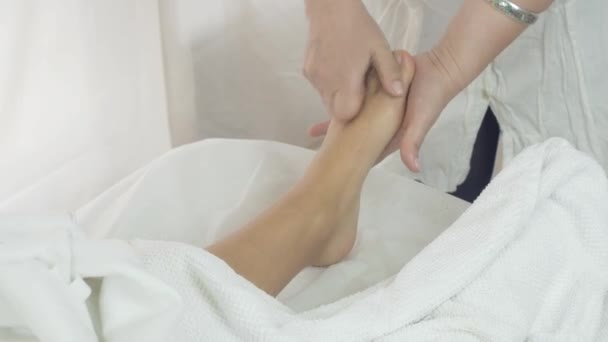 Masseurin massiert die linken Füße der Frau im Salon. Therapieverfahren - Filmmaterial, Video