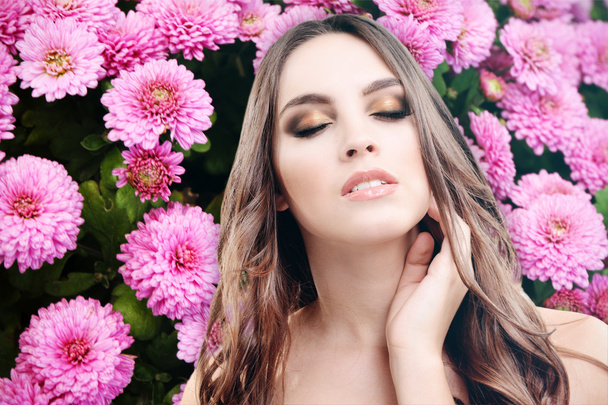 όμορφη γυναίκα σε φόντο με λουλούδια - Φωτογραφία, εικόνα