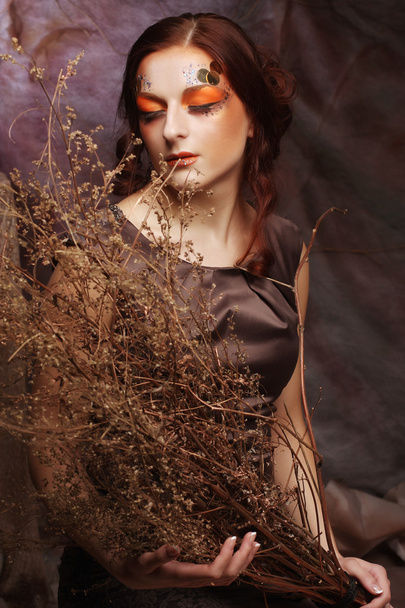 woman with bright make up with dry branches - Φωτογραφία, εικόνα