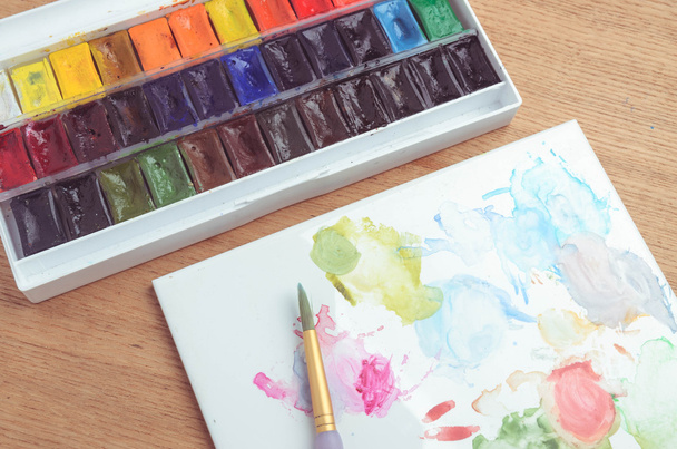Watercolor half-pan paints palette set on wooden background  - Photo, Image
