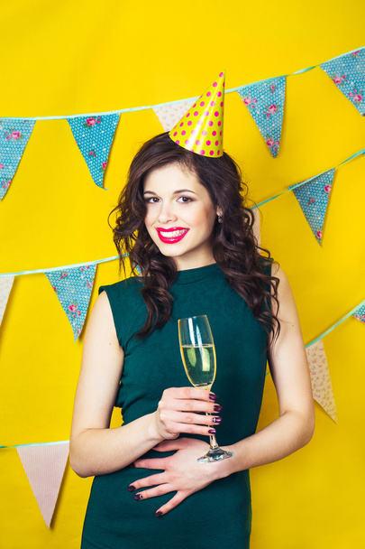 Fiatal nő zöld ruha ünnepli, gazdaság egy pohár pezsgő. - Fotó, kép