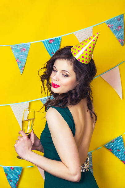Young celebrating woman green dress, holding a glass of champagne. - Foto, Imagen
