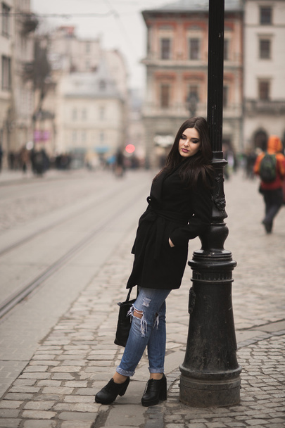 Beautiful brunette young woman posing on the street in old city - Zdjęcie, obraz
