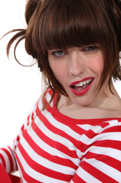 Brunette wearing red and white striped shirt making grimace - Foto, Bild