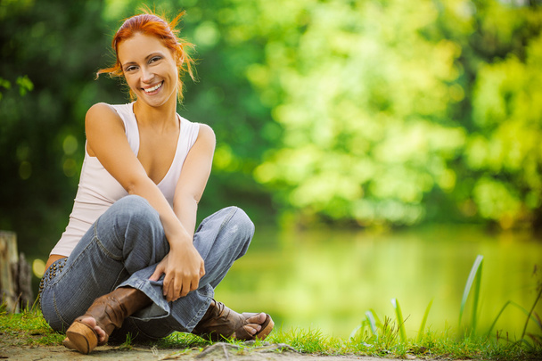 smiling beautiful woman sitting on ground - Fotografie, Obrázek