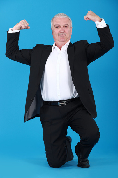 Businessman proudly showing his muscles - Photo, Image