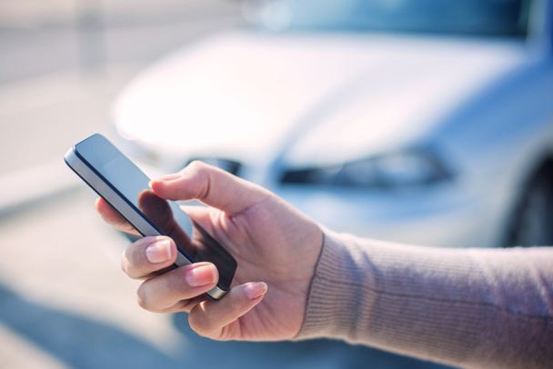 Kobieta za pomocą inteligentny telefon i zadzwonić samochodu ubezpieczenia - Zdjęcie, obraz