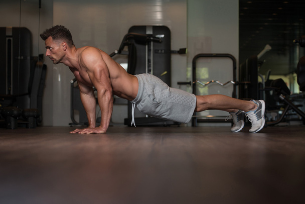 Bodybuilder Doing Push Ups On Floor - Valokuva, kuva