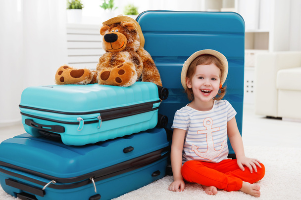 happy child girl collect suitcase on vacation - Valokuva, kuva