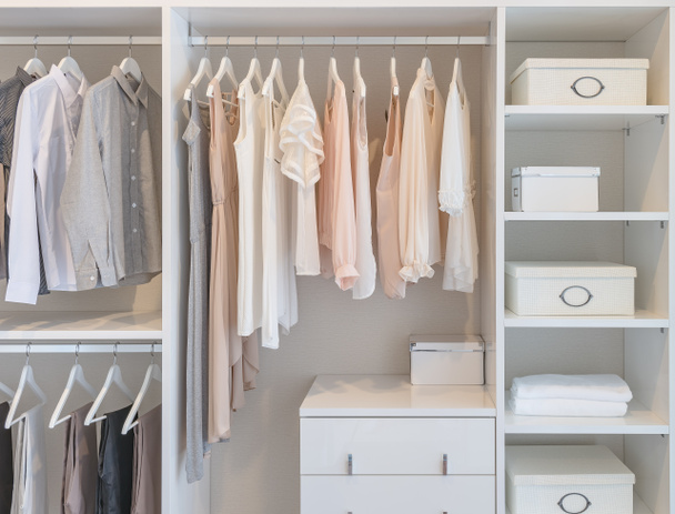ropa colgando en el carril en armario blanco
  - Foto, Imagen