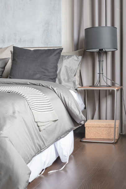 cuscino grigio su letto bianco in camera da letto moderna con lampada nera
  - Foto, immagini