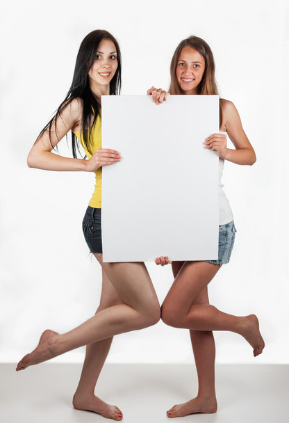 Business smiling girls holds up a white  blank card - Φωτογραφία, εικόνα