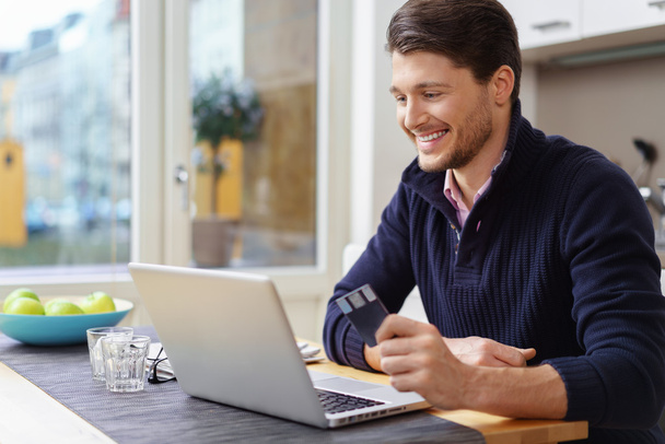 Smiling man with credit card and laptop - Foto, Bild