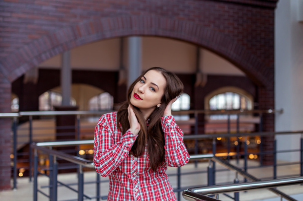 Young beautiful woman in plaid shirt posing in the University - Photo, image