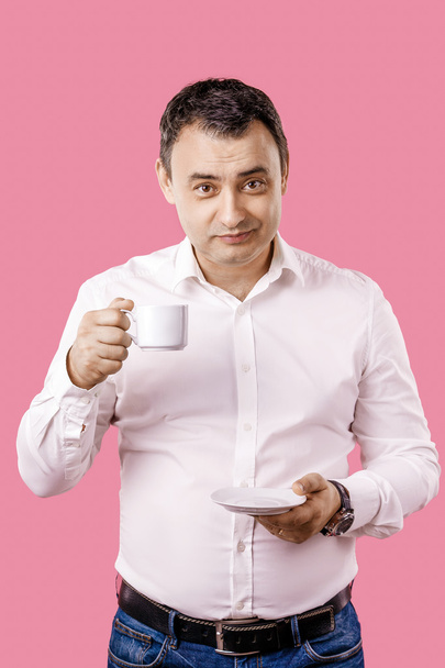 Portrait happy, smiling business man, lawyer drinking cup coffee isolated pink background. Human face expression, emotion, corporate executive. - Photo, image