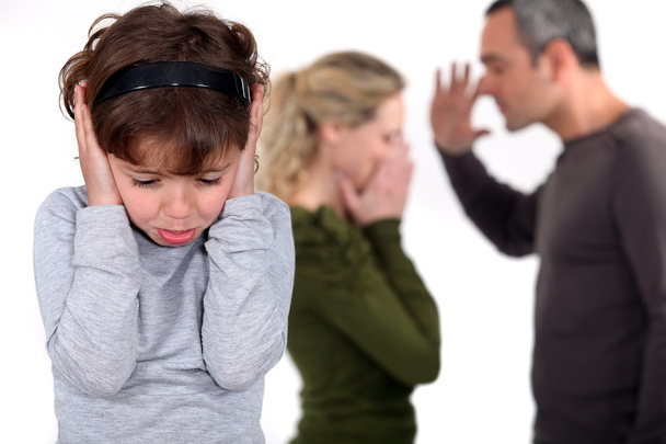 Young girl trying to block out the sound of her parents arguing - Fotoğraf, Görsel