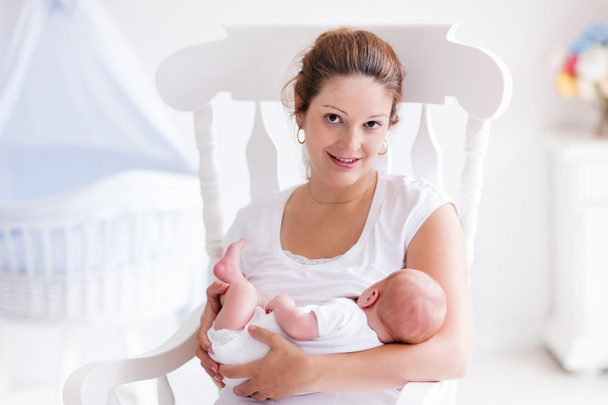 Mãe e bebê recém-nascido em berçário branco
 - Foto, Imagem