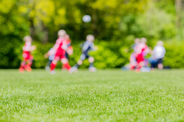 Blurred kids playing youth football match - Фото, изображение