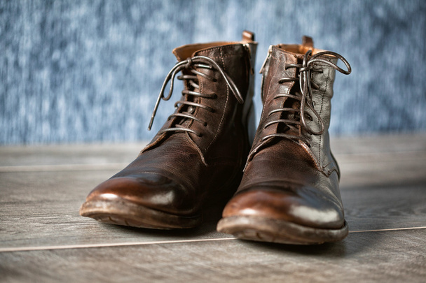 Закройте новую пару коричневых кожаных туфель. холодные высокие ботинки на деревянной поверхности
 - Фото, изображение