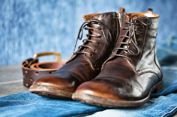коричневые туфли, синие джинсы и ремень на абстрактном фоне
 - Фото, изображение