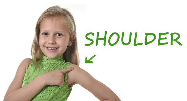 χαριτωμένο μικρό κορίτσι δείχνει τον ώμο της σε μέρη του σώματος εκμάθηση αγγλικών λέξεων στο σχολείο - Φωτογραφία, εικόνα