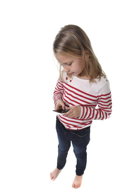 beautiful female child with blond hair and blue eyes using mobile phone playing game - Foto, immagini