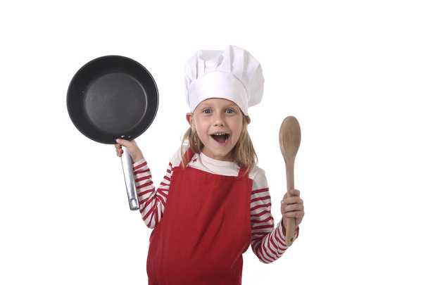 6 or 7 years old little girl in cooking hat and red apron playin - Fotografie, Obrázek