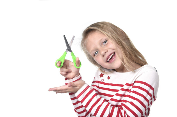 dulce hermosa niña de 6 a 8 años de edad sosteniendo corte tijeras escuela suministros concepto
 - Foto, Imagen