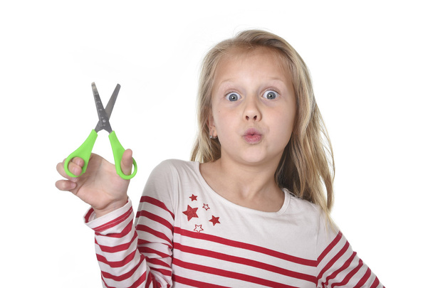 sweet beautiful female child 6 to 8 years old holding cutting scissors school supplies concept - Photo, image