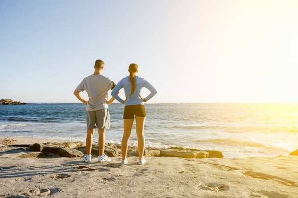 Young couple on beach training together - 写真・画像
