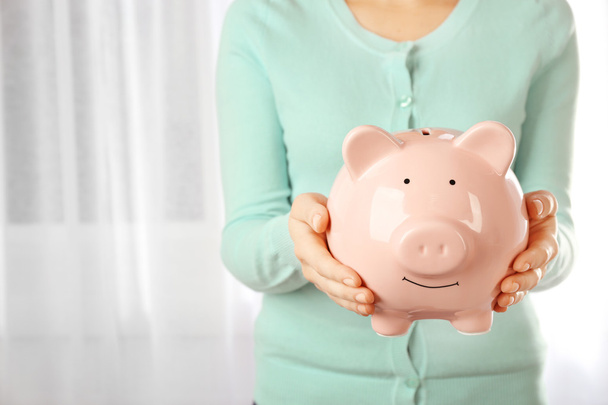Woman holding piggy bank in hands  - Photo, Image