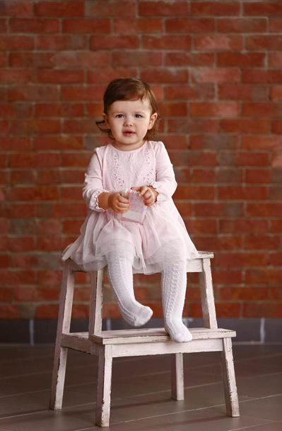 Little girl sitting on chair  - Fotó, kép