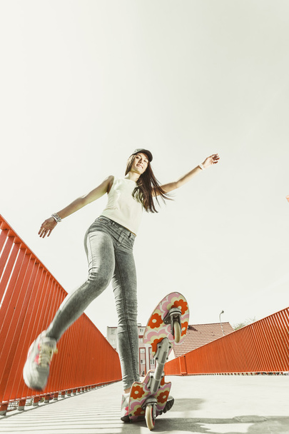 Teen girl skater riding skateboard on street. - Фото, изображение