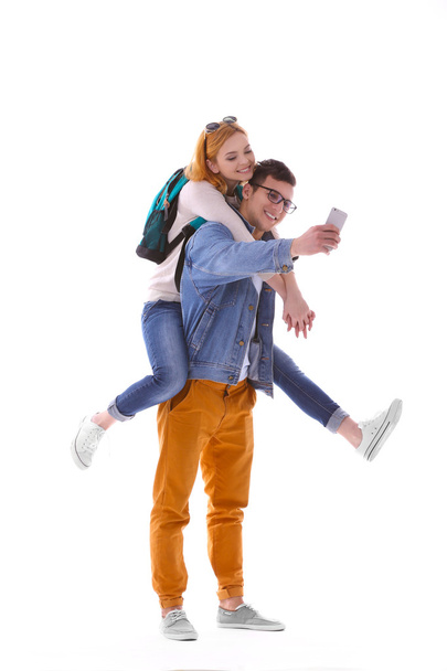 Young couple taking selfie with mobile phone isolated on white - Φωτογραφία, εικόνα