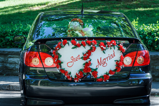 "Frisch verheiratet" -Schild auf der Rückseite eines Autos, das auf das Brautpaar wartet - Foto, Bild