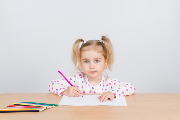 小さな女の子をテーブル鉛筆で描画します. - 写真・画像