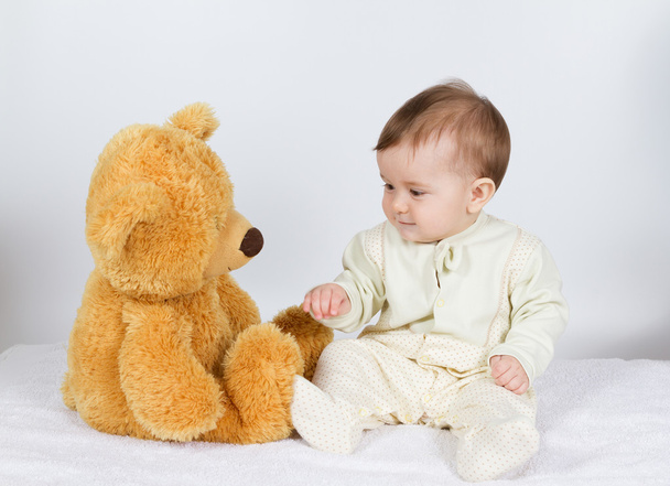 Little boy baby sitting next to a teddy bear - Фото, зображення
