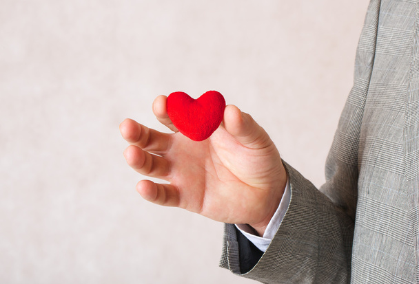 A red heart in a man's hand.Closeup - Foto, Bild