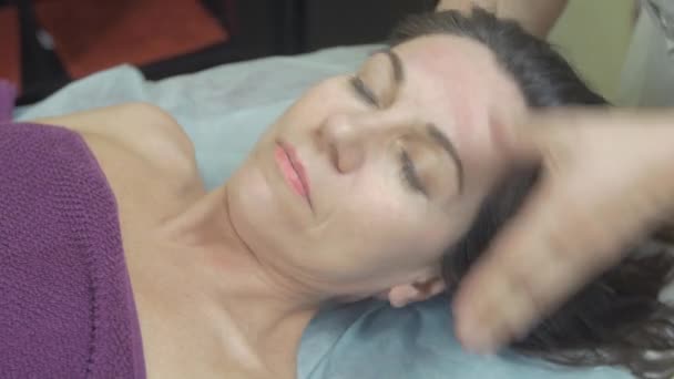 Masseuse make healing massage of neck to young woman in professional saloon. - Footage, Video