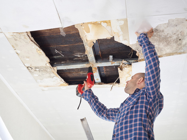 человек ремонтирует рухнувший потолок
 - Фото, изображение